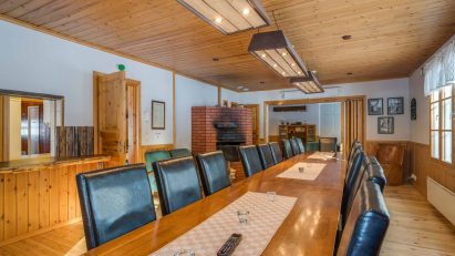 At the table in the main hall of Evo Ruuhijärvi, there is space for a meeting, dining, or social gathering for 18-20 participants.