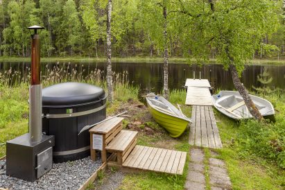 The hot tub, pier, and boats of Evo Grand Villa's lakeside sauna are located on the shore of Lake Kaitalammi.