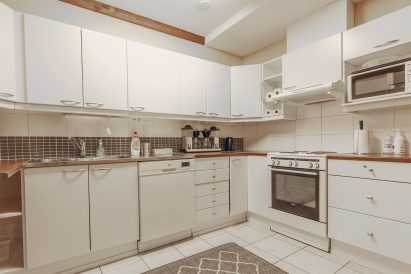 Ground floor kitchen of Evo Grand Villa is equipped with fridge, dishwasher, stove/owen, coffee maker and microwave.