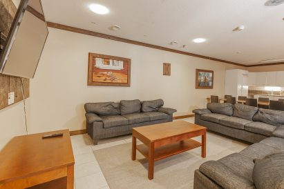 The living room on the lower floor of Evo Grand Villa. In the background, you can see the spacious kitchen facilities.