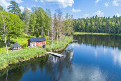 An autumn view for Evo Grand Villa's traditional lakeside sauna and barbecue shelter. The rowboat is available for boating and fishing in Lake Kaitalammi.