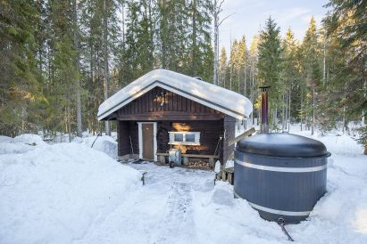 In front of Evo Wilderness Villa's wood-heated outdoor sauna is another of the wood-heated hot tubs.