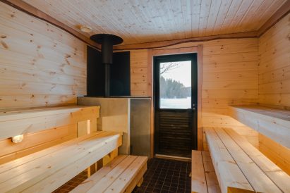The sauna room of the wood-heated sauna located at the other end of Aulanko Lake Villa, with direct access to the terrace and the lake.