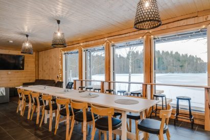 Aulanko Lake Villa's main hall. In the foreground, a dining table and a scenery bar counter.