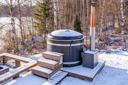Next to the terrace of Aulanko Lake Hide-out, there is a wilderness-style fireplace and a wood-heated hot tub.