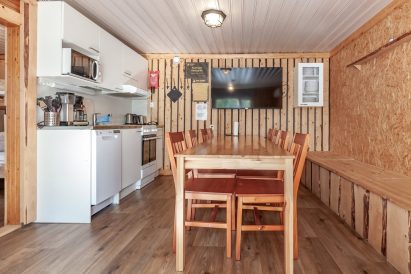In the living room and kitchenette of Aulanko Lake Hide-out, there is space at the table for dining or a meeting for 8-9 people.