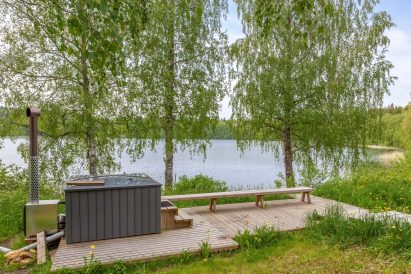 View of Lake Aulangonjärvi from the front of Aulanko Grand Villa's beach sauna. In the foreground, a wood-heated hot tub.