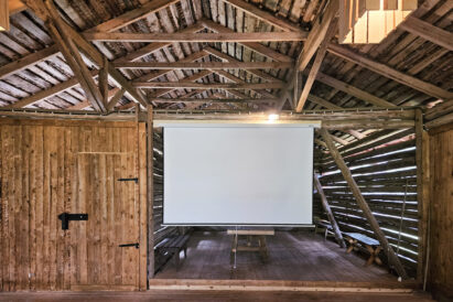 Above the Wilderness Barn stage, there is a fixed pull-down projection screen.