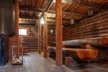 The interior of Evo Ruuhijärvi's Event Shed is dominated by sturdy bench and table sets made from split logs.