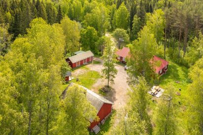 The courtyard of Evo Ruuhijärvi in its summer attire. On the right, the main building; in front, the Event Shed; in the middle, the accommodation cabin; and the storage building.