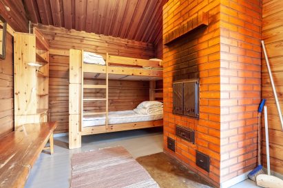 In the dressing room of the larger lakeside sauna at Evo Ruuhijärvi, there is a bunk bed with two sleeping places and a sturdy brick stove.