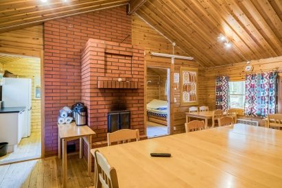 The robust brick-built fireplace adds ambiance to the main hall of Evo Syväjärvi. A retractable screen is also available on the side wall of the hall.