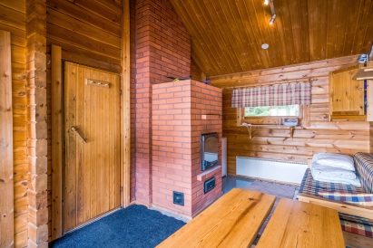 In the dressing room of Evo Syväjärvi's sauna building, there is an atmospheric brick stove. In the corner, there is also a fridge for sauna drinks. The fold-out sofa can be used as a 1-2 person bed.