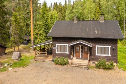 Evo Wilderness Villa from the direction of Niemisjärventie road. The wood-heated courtyard sauna is hidden in the forest garden on the back left.