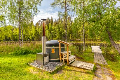The hot tub and pier of Evo Grand Villa's lakeside sauna are located on the shore of Lake Kaitalammi.