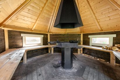 The atmospheric grill hut of Evo Grand Villa offers plenty of seating space around an open fire.