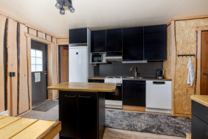 The open kitchen at Tavastia Privacy is equipped with a refrigerator/freezer, microwave, coffee maker, stove/oven, and dishwasher.