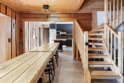 The tables in the hall of Tavastia Privacy conveniently extend from the open kitchen. Stairs lead to the upstairs accommodation.