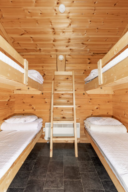 The middle room of the year-round accommodation cabin at Loppi Wilderness Villa has four beds.