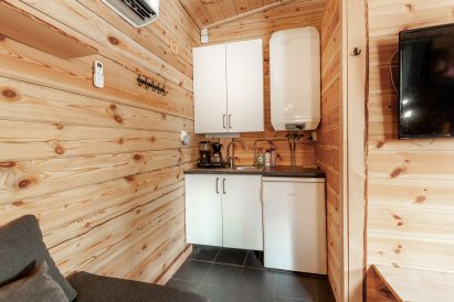 The kitchen corner of Loppi Wilderness Villa's Mini Villa is equipped with a refrigerator, running cold and hot water, and a coffee maker.