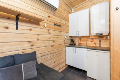The kitchen corner of Loppi Wilderness Villa's Mini Villa is equipped with a refrigerator, running cold and hot water, and a coffee maker.