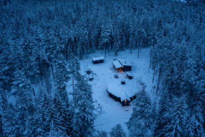 The winter evening darkens at Loppi Wilderness Villa. In the foreground is the Main Villa, in the middle the Mini Villa and behind the accommodation cabin.