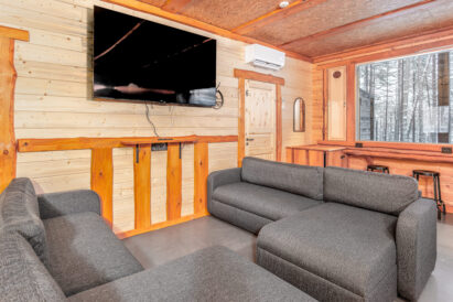 The sofa group in the main hall of Loppi Luxus and one of the hall's smart TVs. In the background, the scenery bar counter along the window wall.