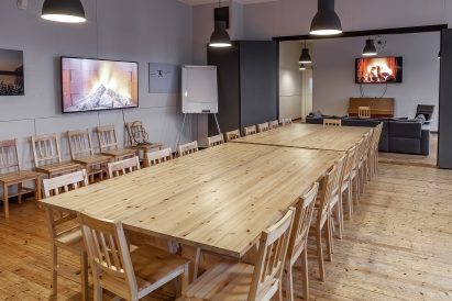The main hall of Räyskälä Grand Villa features two widescreen televisions and a piano. The arrangement and number of tables can be adjusted according to needs.