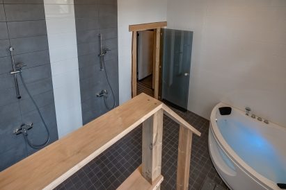 In the downstairs electric sauna section of Räyskälä Grand Villa, there is a shower room with a toilet and a jacuzzi.