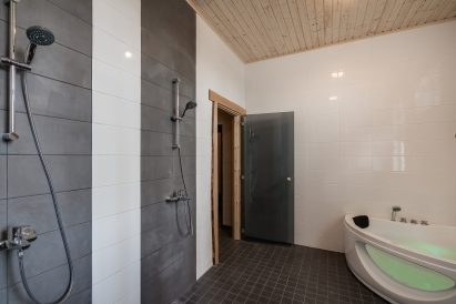 In the downstairs electric sauna section of Räyskälä Grand Villa, there is a shower room with a toilet and a jacuzzi.