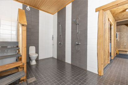 In the downstairs electric sauna section of Räyskälä Grand Villa, there is a shower room with a toilet.