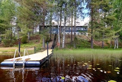 From the lake-facing open terrace of Räyskälä Grand Villa, stairs lead down to the boat dock and pier.